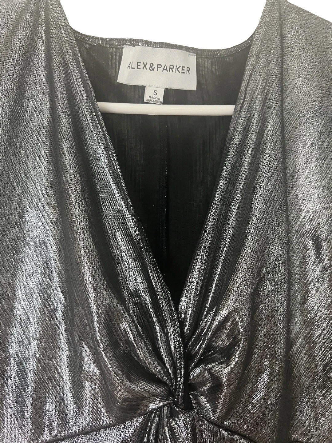 Metallic silver blouse has a V-neck and a twisted knot detail at the front