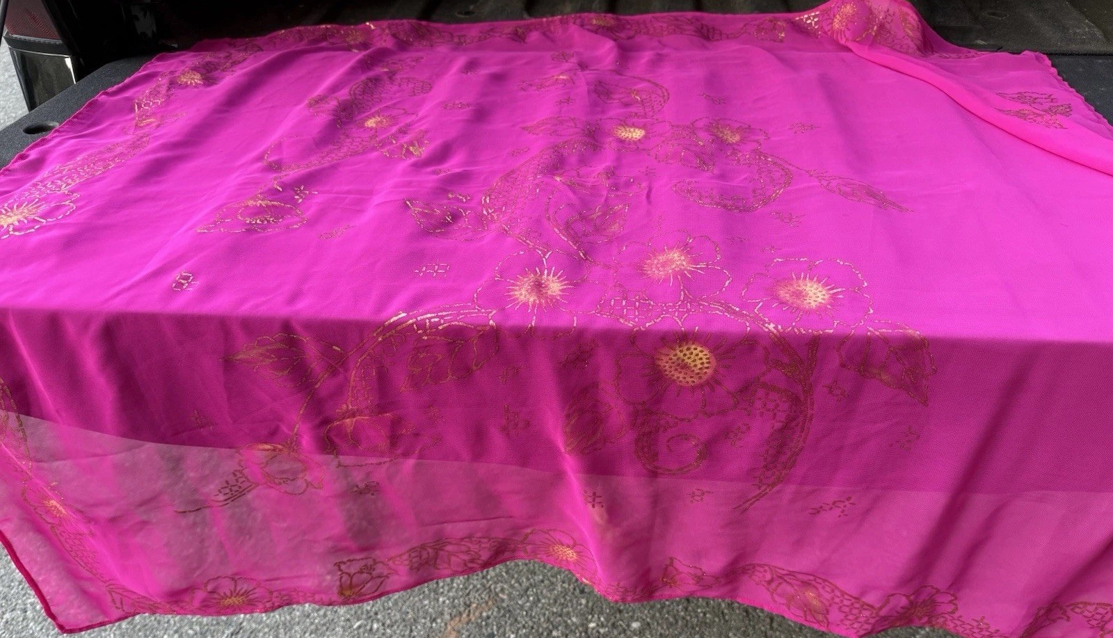 magenta sheer scarf with a gold floral pattern.