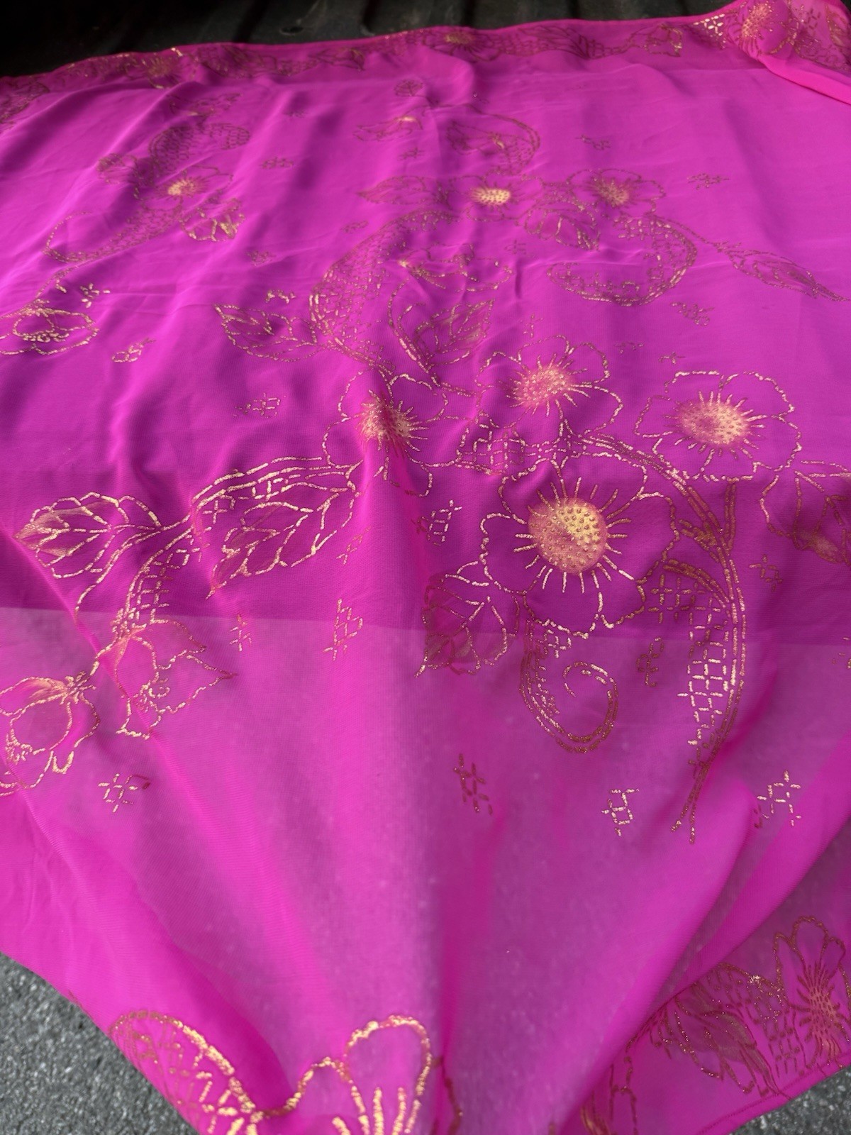 magenta sheer scarf with a gold floral pattern.