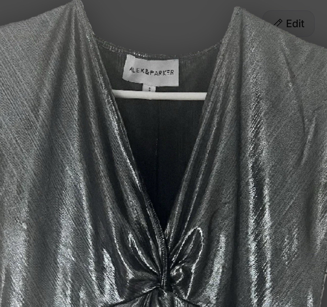 Metallic silver blouse has a V-neck and a twisted knot detail at the front