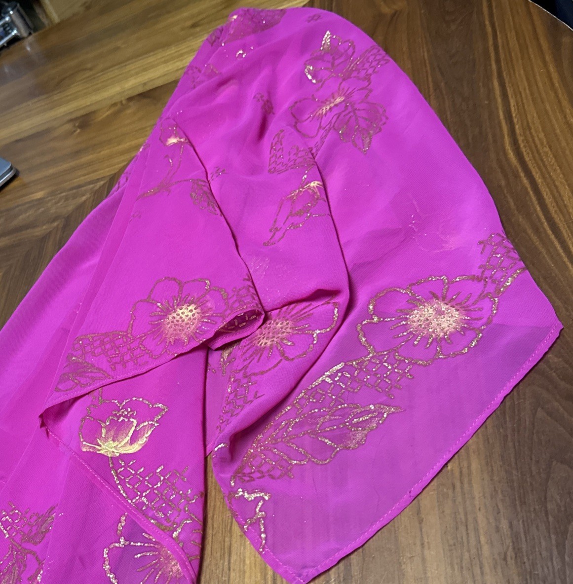 magenta sheer scarf with a gold floral pattern.