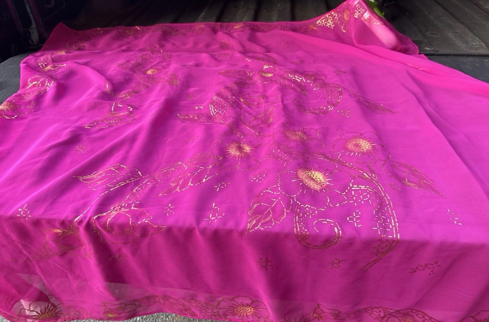 magenta sheer scarf with a gold floral pattern.