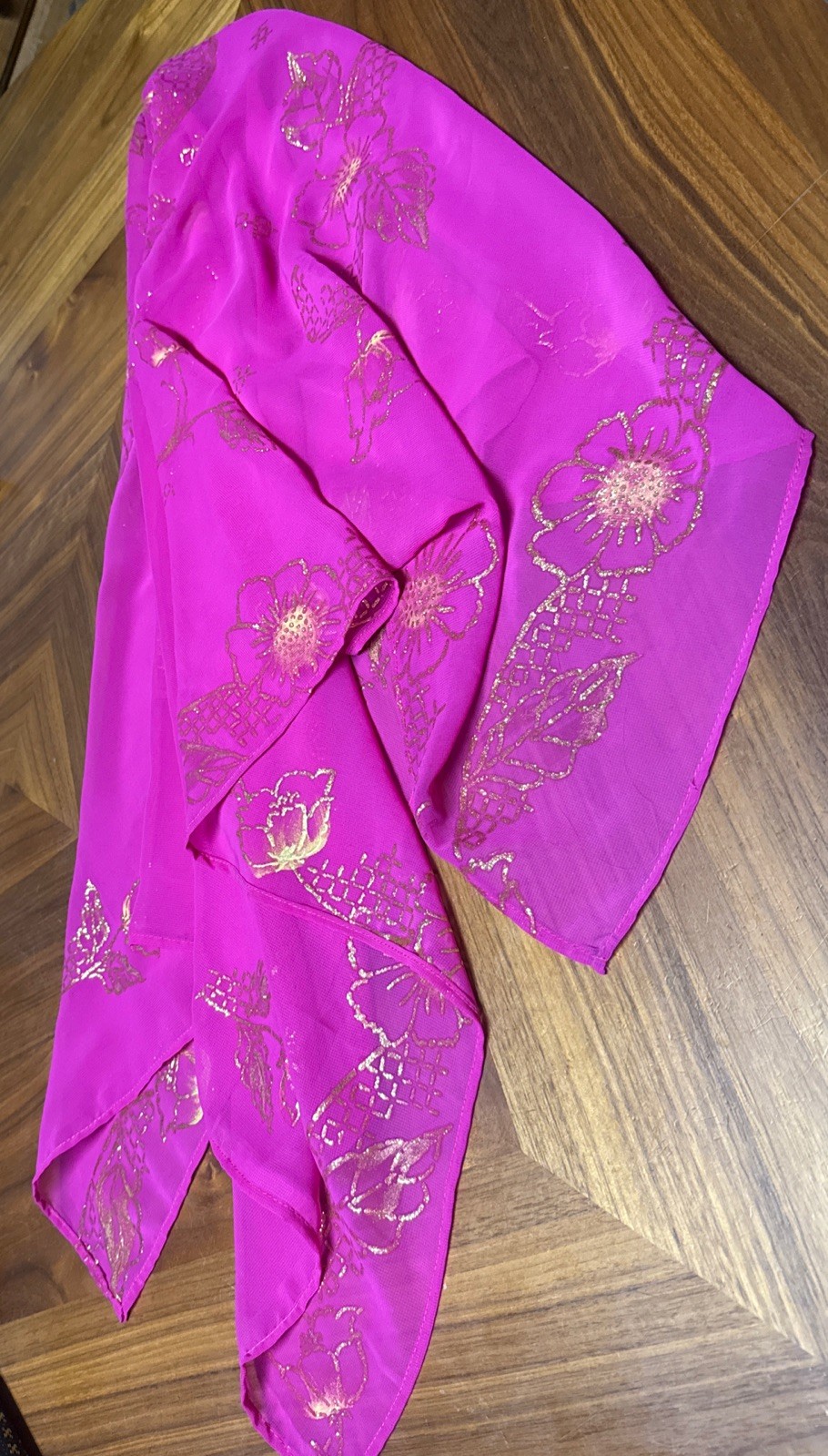 magenta sheer scarf with a gold floral pattern.