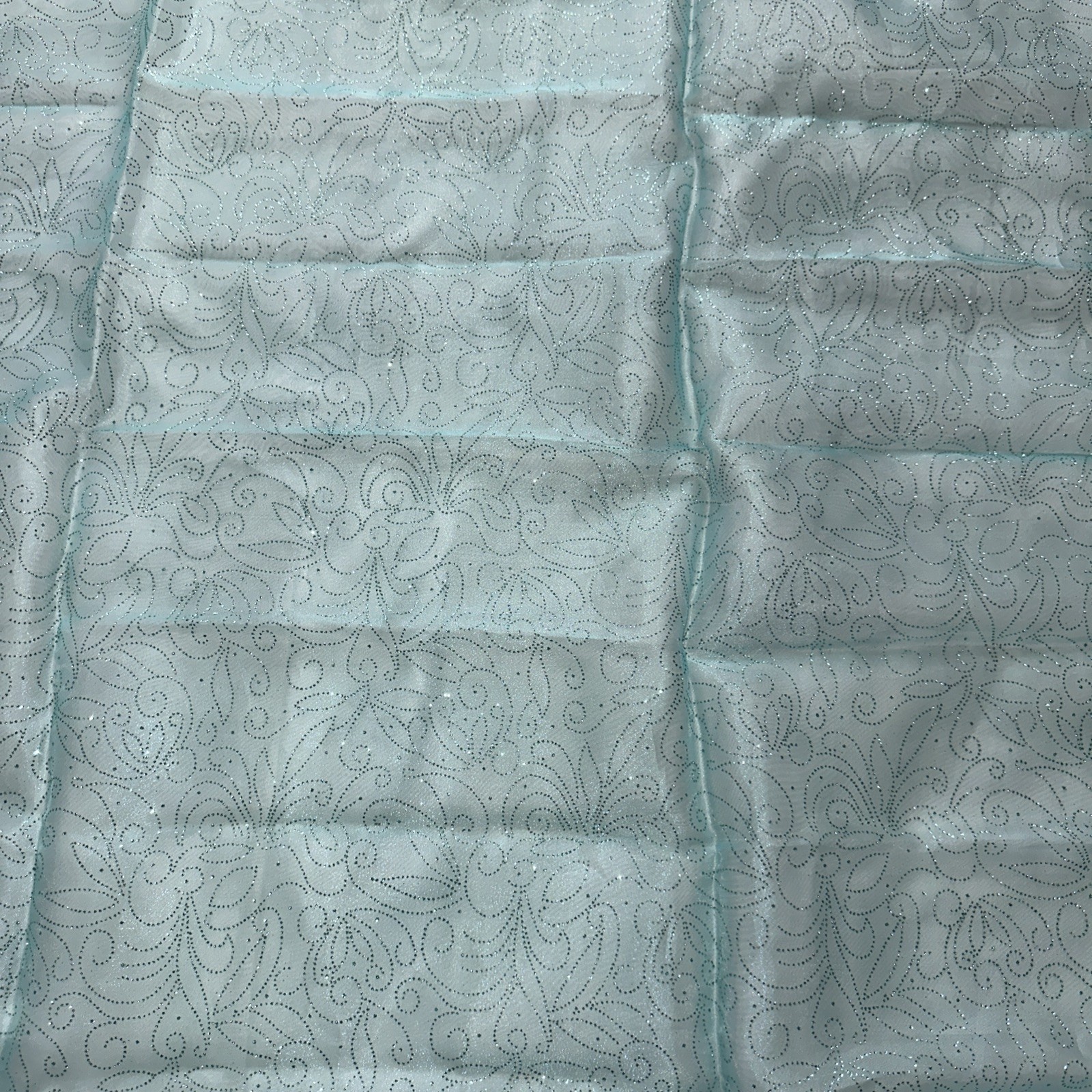 light blue metallic fabric with swirling glitter design. 72”x 59”