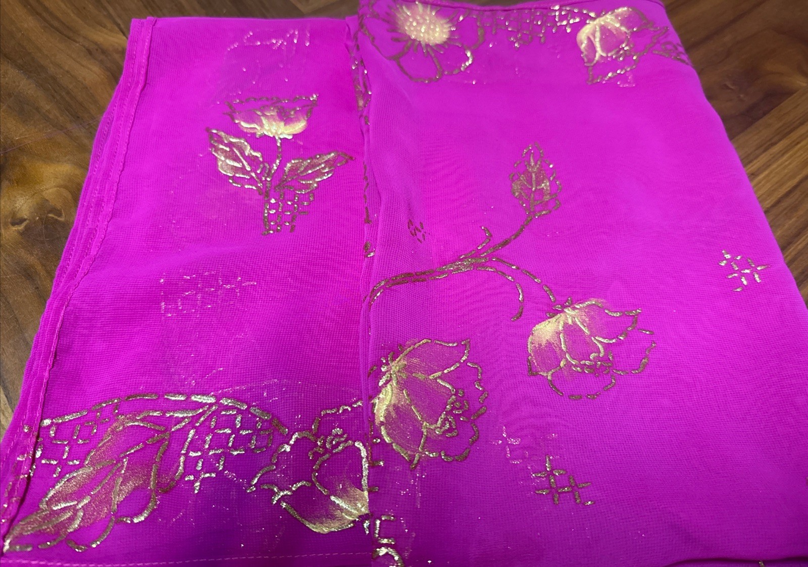 magenta sheer scarf with a gold floral pattern.