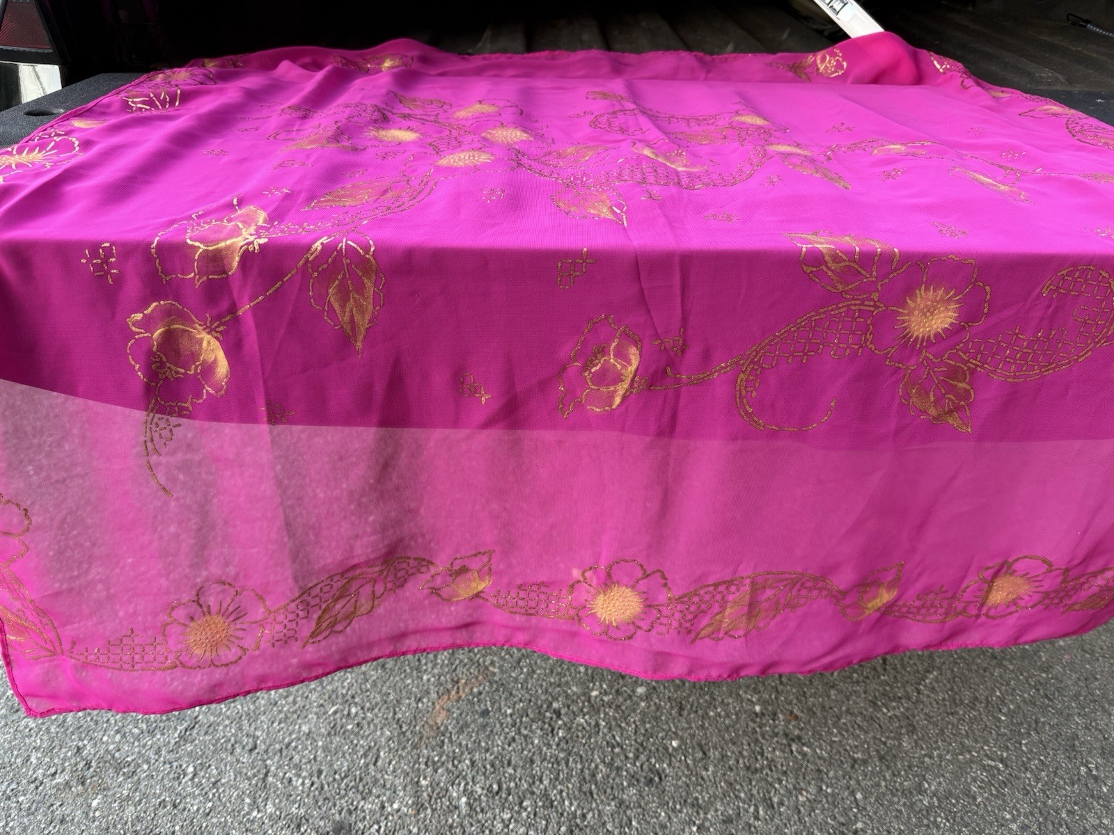 magenta sheer scarf with a gold floral pattern.