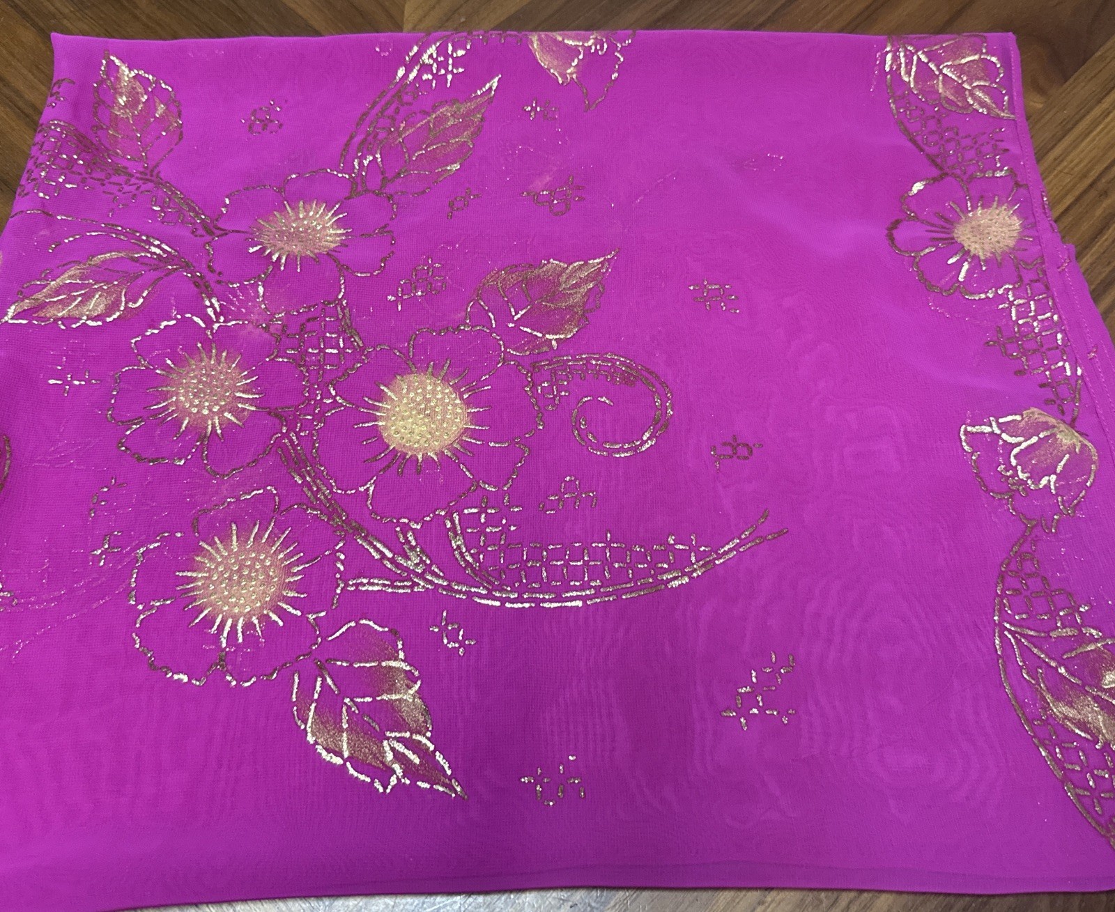 magenta sheer scarf with a gold floral pattern.